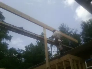 Carpenter setting a ridge beam over a new addition frame — Ice Dam Removal by Roofing Brothers in Maple Shade