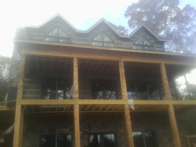Dormers and porch framing on a large log home under construction — Roof Coating work by our crew in Maple Shade