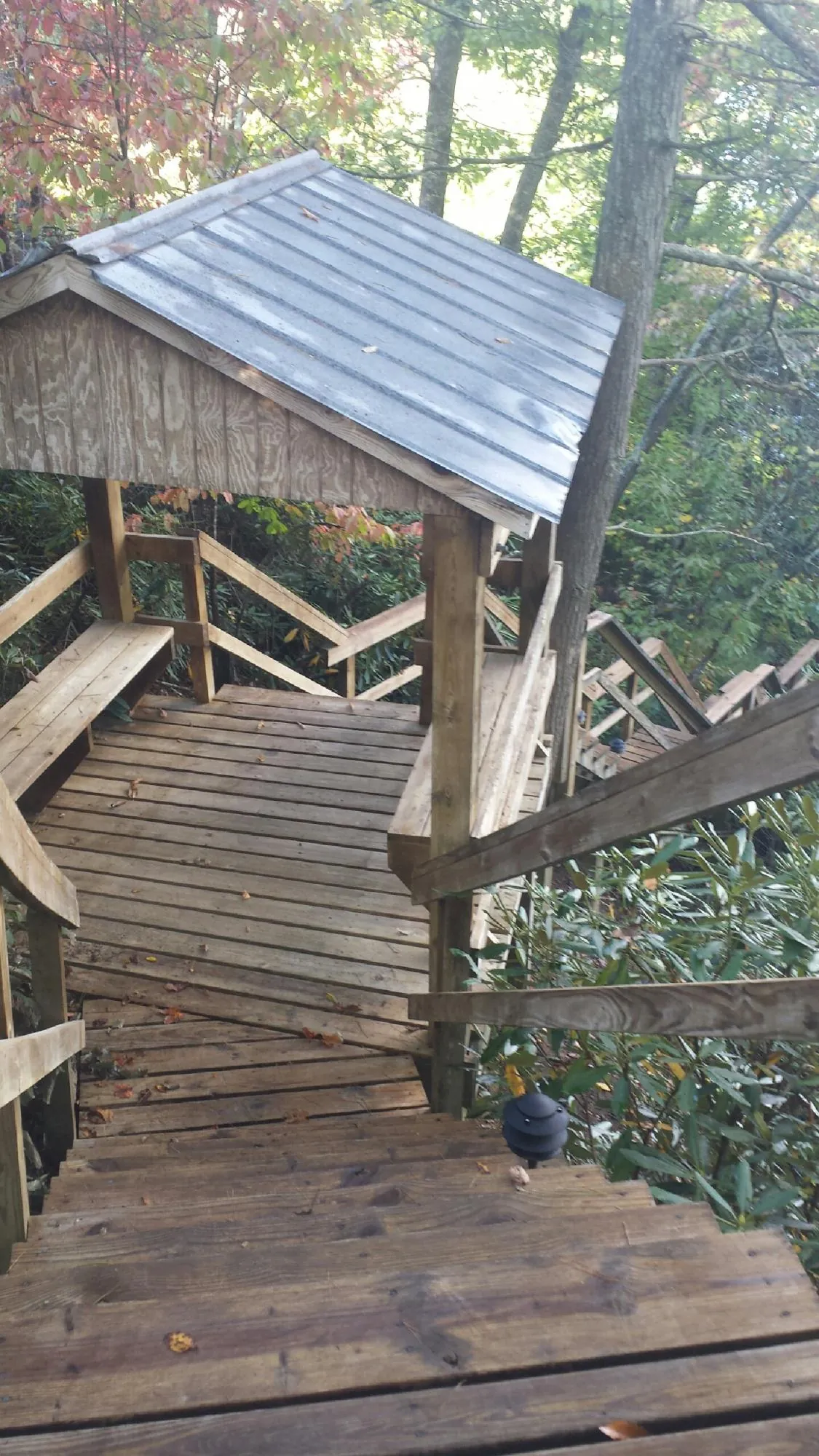 Metal roofed shelter over wooden steps on a wooded walkway — Skylight Repair & Installation work by our crew in Maple Shade